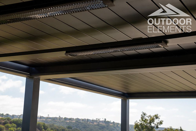 Twin infrared heaters mounted under pergola roof with hillside view