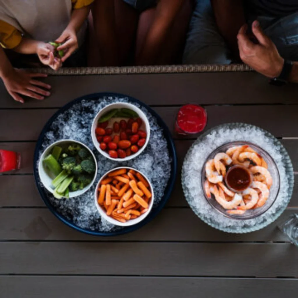 Overhead view of shrimp, salsa and dips served on an outdoor dining table