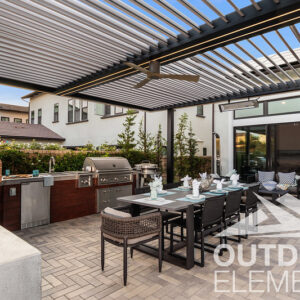 Patio with pizza oven, outdoor kitchen, and dining table under louvered pergola roof