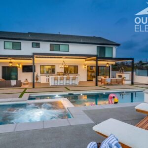 Backyard pool and spa with pergola-covered patio and outdoor bar at twilight