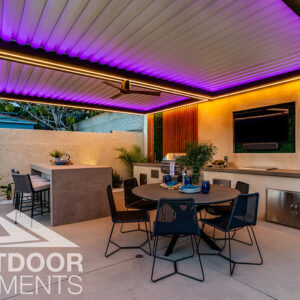 Outdoor dining and bar area under pergola with purple LED lighting at dusk