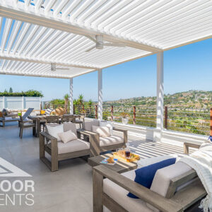 White louvered pergola shading outdoor lounge furniture with hillside view