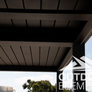 Close-up corner detail of black louvered pergola roof against blue sky