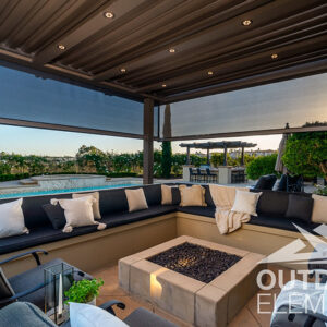 Built-in sectional seating around fire pit under pergola with retractable screens