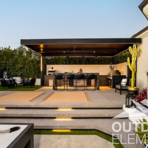 Modern backyard with black pergola outdoor kitchen, bocce court, and sauna at dusk